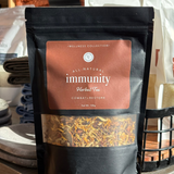 Bag of All-Natural Immunity Herbal Tea from Wellness Collection on a wooden surface.
