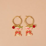 Gold hoop earrings with wine glass and bow designs on a beige background