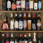 Shelf displaying a variety of wine bottles with different labels.