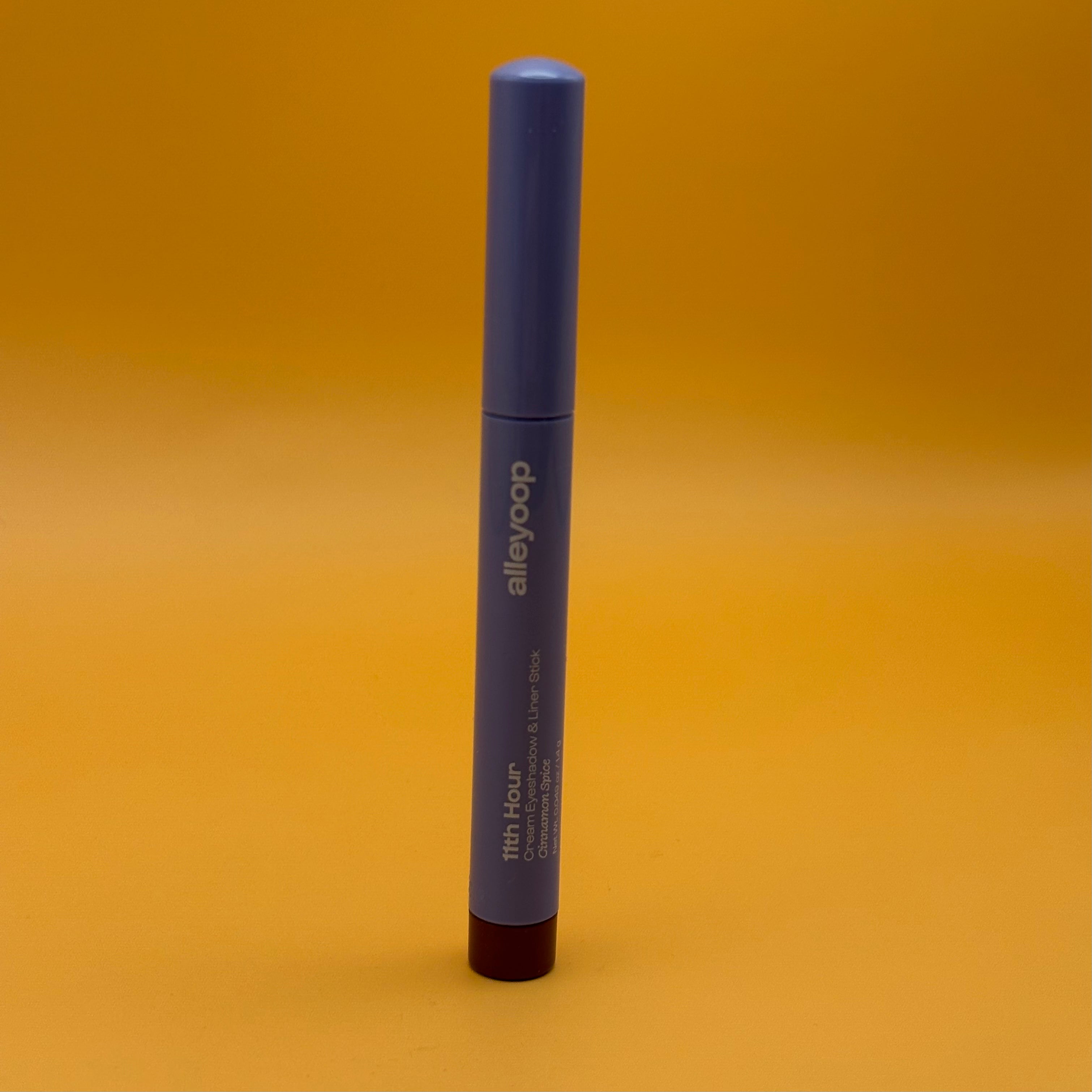 Blue cosmetic pencil with 'alleyoop' branding on a yellow background