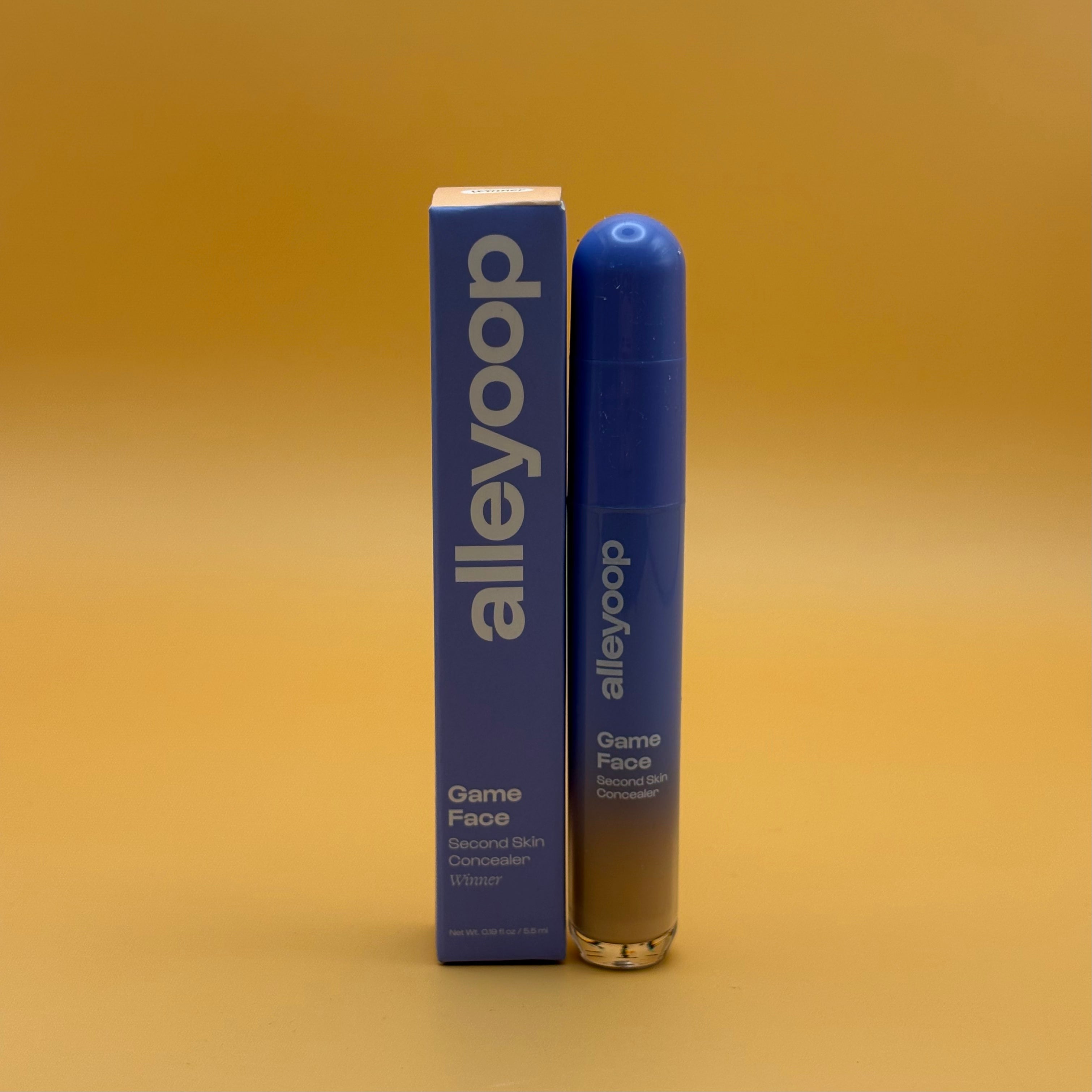 Alleyoop Game Face concealer winner bottle and packaging on a yellow gradient background