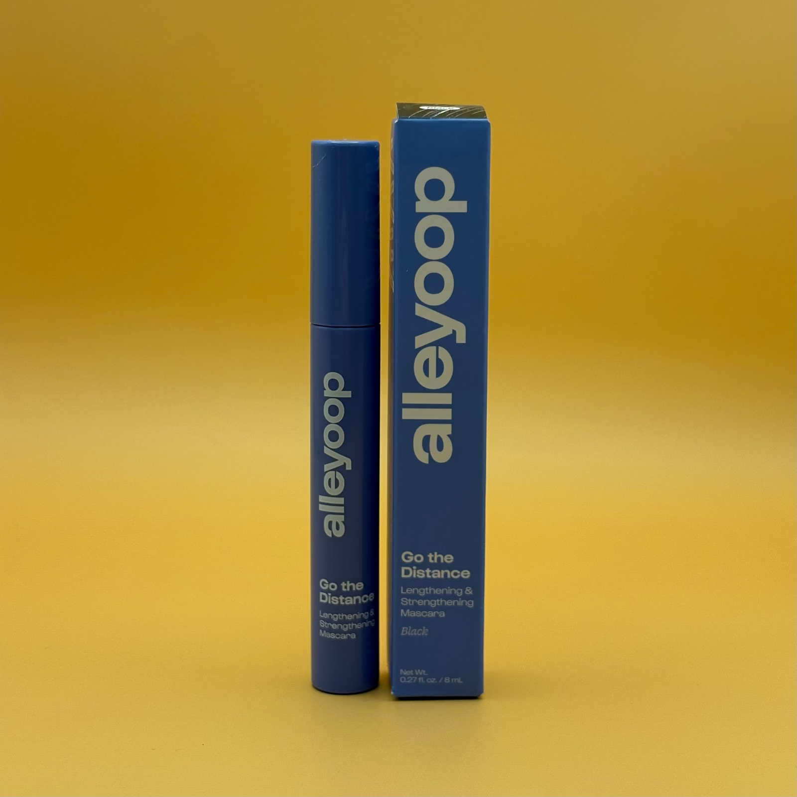 Black mascara product and packaging with 'alleyoop' branding on a yellow background