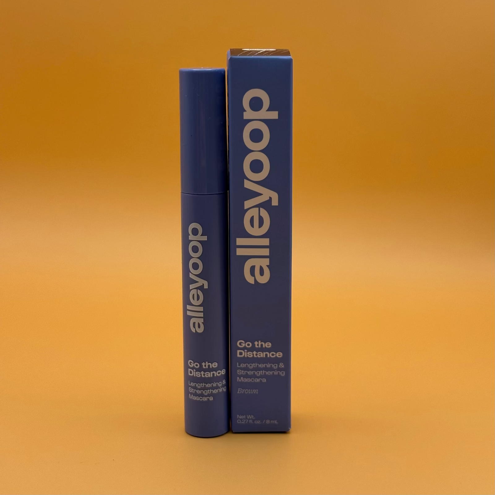 Alleyoop brown mascara product packaging on an orange background