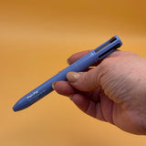 Hand holding a blue alleyoop pen pal in a rouge color with a clear cartridge on an orange background