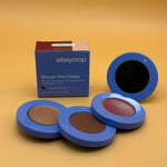 Alleyoop makeup set with three compact cases and a blue box on a yellow background