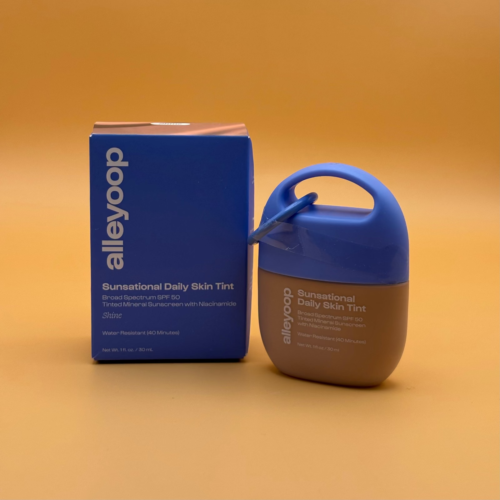 Blue box with 'alleyoop' branding of sunsational skin tint named shine on an orange background