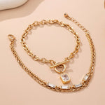 Layered gold-tone necklace with baguette crystals and toggle clasp