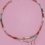Double layer beaded necklace with heart and bow charm