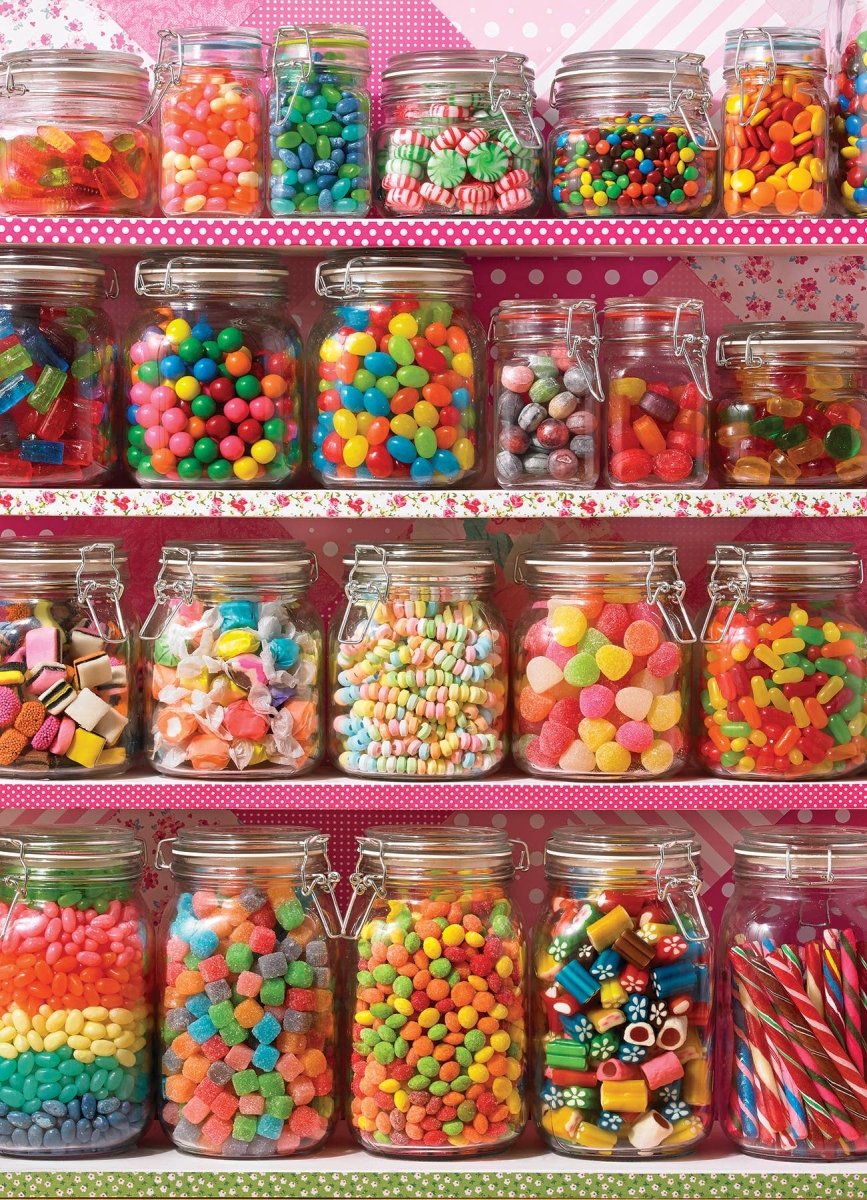 Shelf with various jars of colorful candies against a pink polka dot background