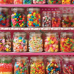 Shelf with various jars of colorful candies against a pink polka dot background