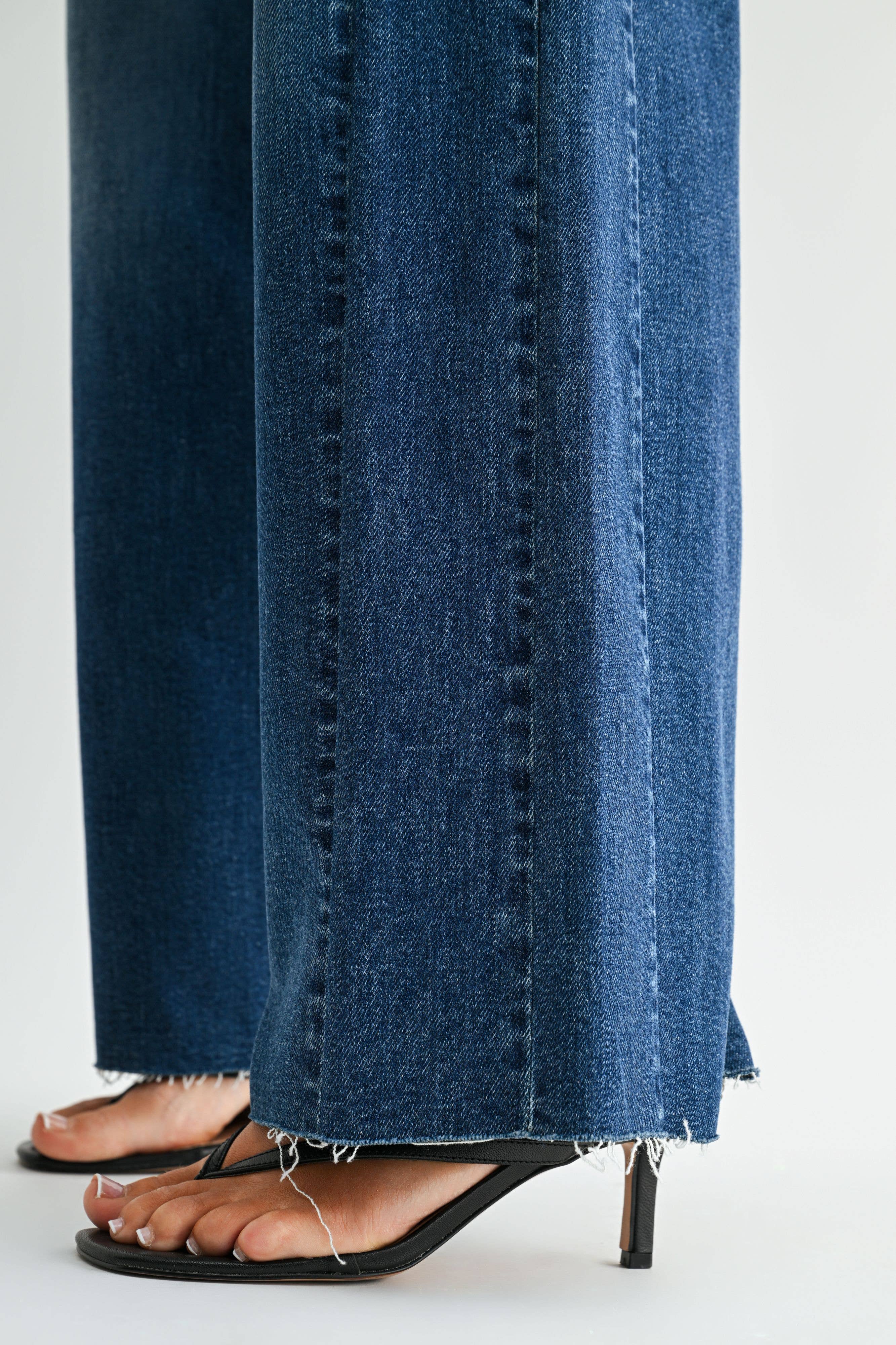 Dark wash wide leg jeans with a raw hem finish