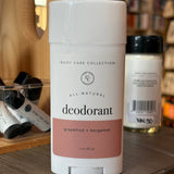 All-natural rowe casa deodorant container on a wooden shelf with blurred background. 