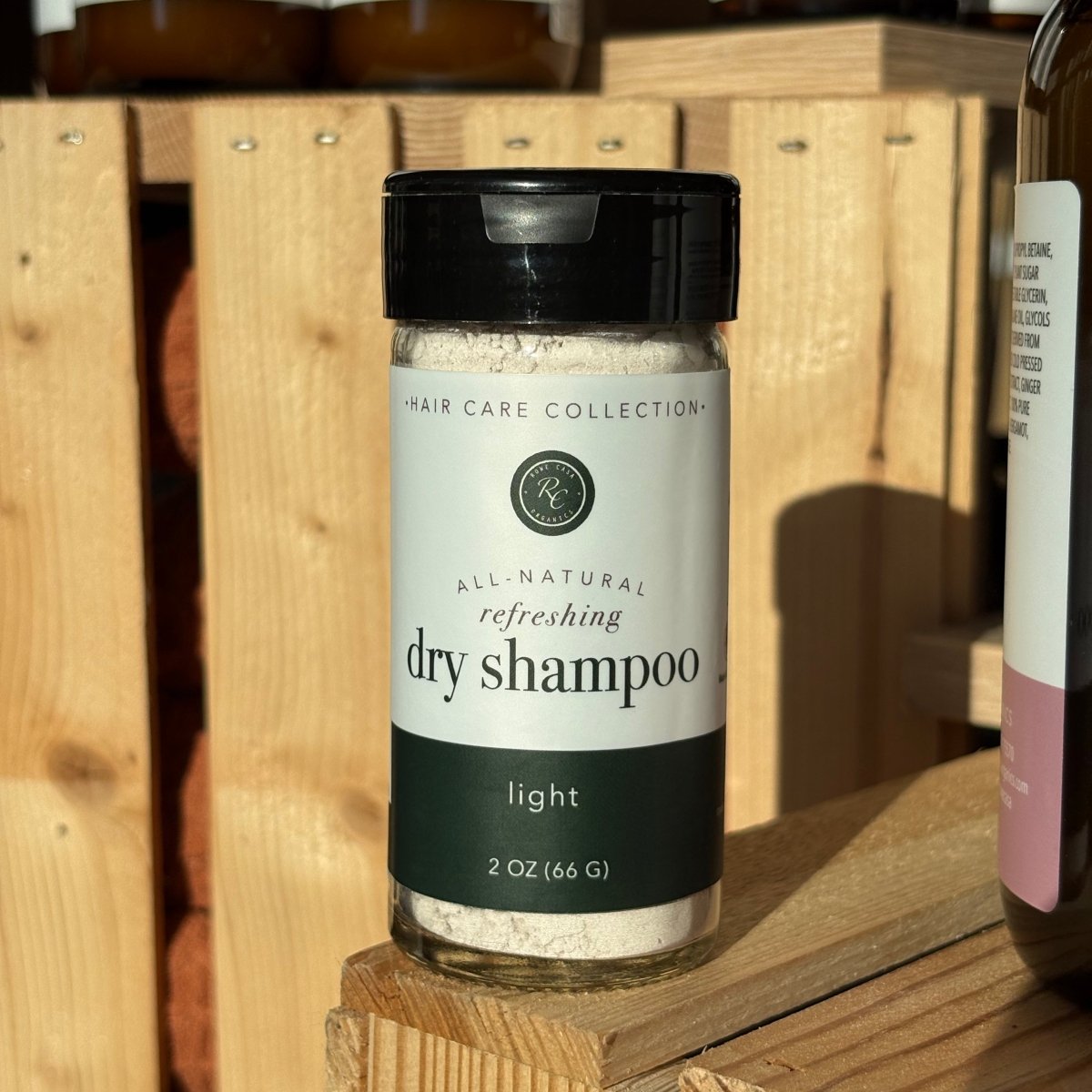 Jar of rowe casa dry shampoo on a wooden shelf. 