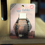 Bracelet on a card with 'fahlo' branding and elephant design, placed on a wooden surface.