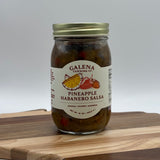 Jar of Pineapple Habanero Salsa with Galena Canning Co. label on a wooden surface.