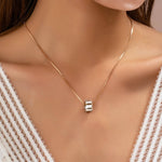 Gold-tone necklace with baguette crystal barrel pendant
