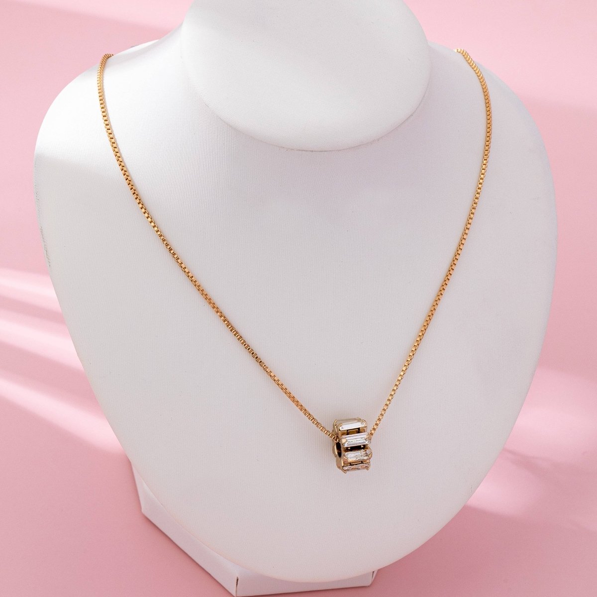 Gold-tone necklace with baguette crystal barrel pendant