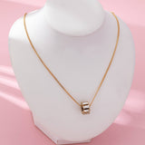 Gold-tone necklace with baguette crystal barrel pendant