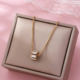 Gold-tone necklace with baguette crystal barrel pendant