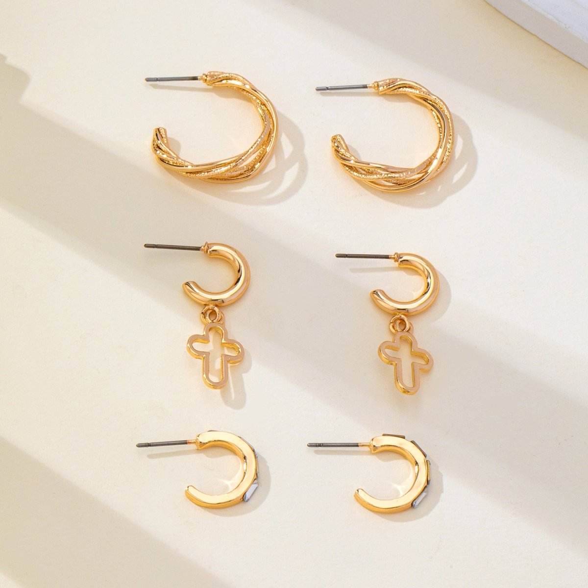 Gold-tone hoop earring trio set with cross and baguette accents
