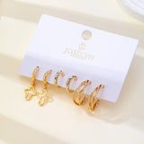 Gold-tone hoop earring trio set with cross and baguette accents