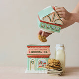 A hand-painted ceramic cookie jar shaped like a bookstore with a snowman, reading Christmas and Co.