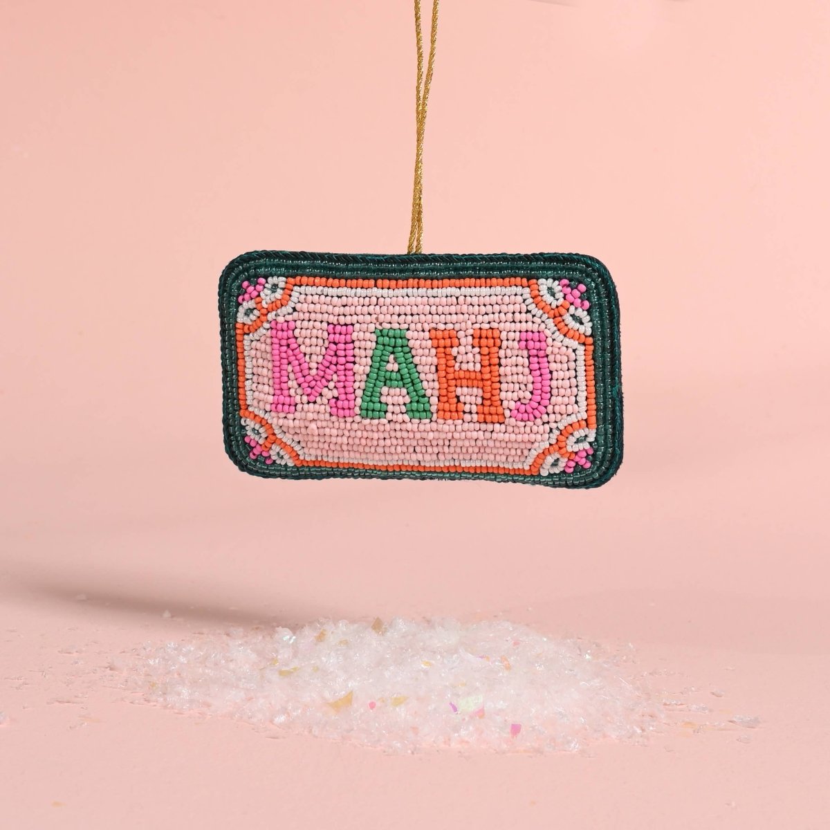 Decorative ornament with 'MAHJ' text on a pink background