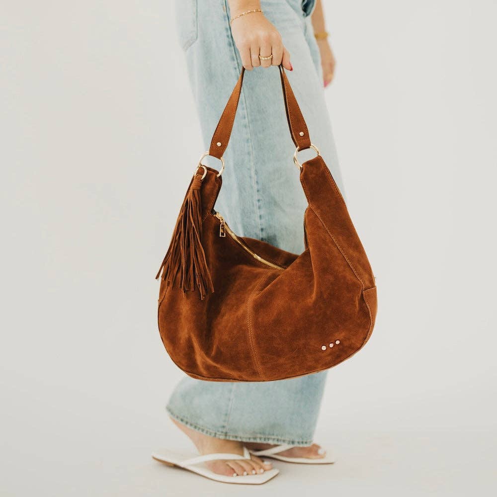 Tan suede hobo shoulder bag with a tassel