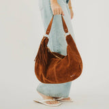 Tan suede hobo shoulder bag with a tassel