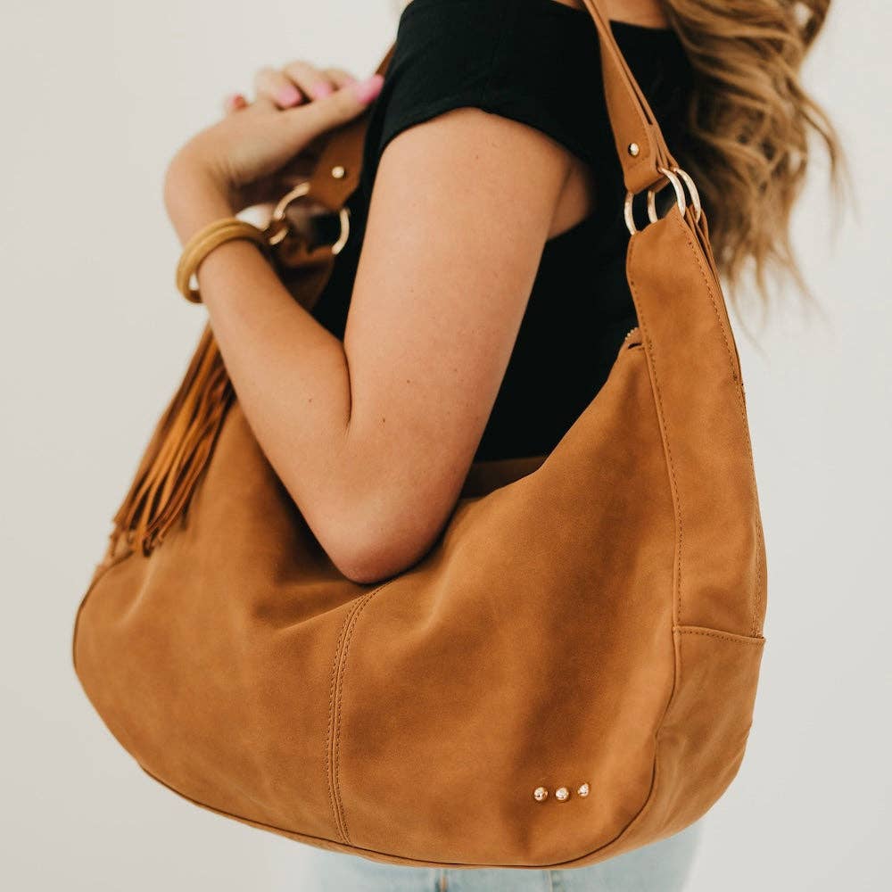 Tan suede hobo shoulder bag with a tassel