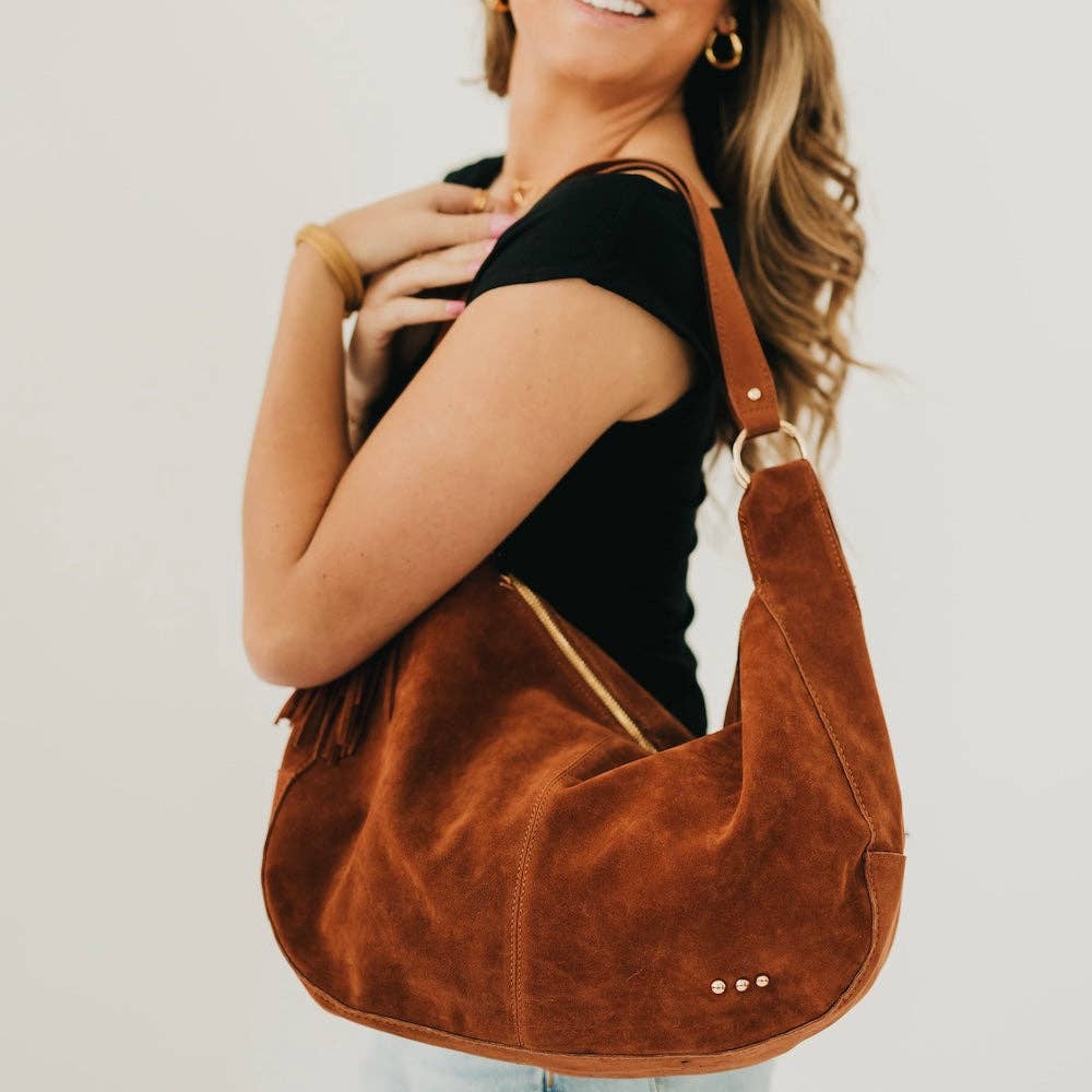 Tan suede hobo shoulder bag with a tassel