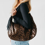 Tan suede hobo shoulder bag with a tassel