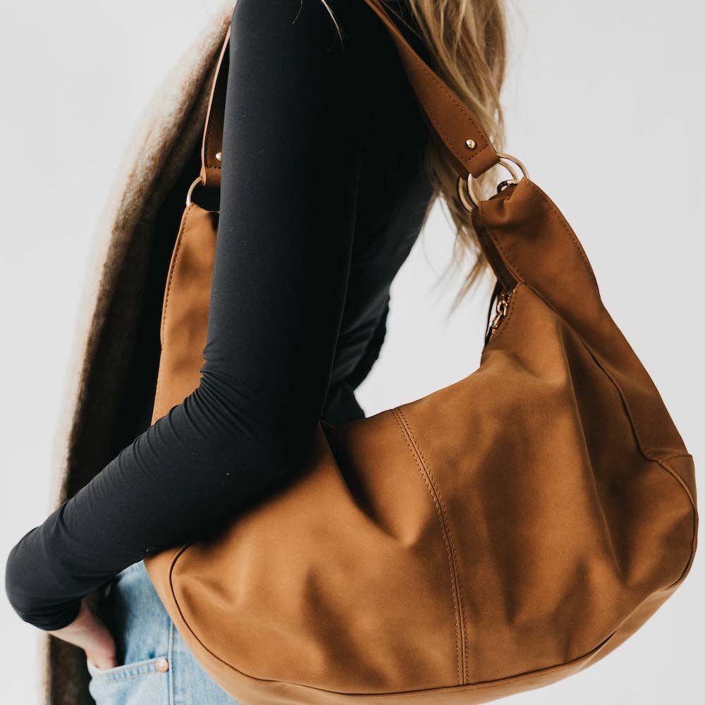 Tan suede hobo shoulder bag with a tassel