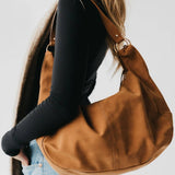 Tan suede hobo shoulder bag with a tassel