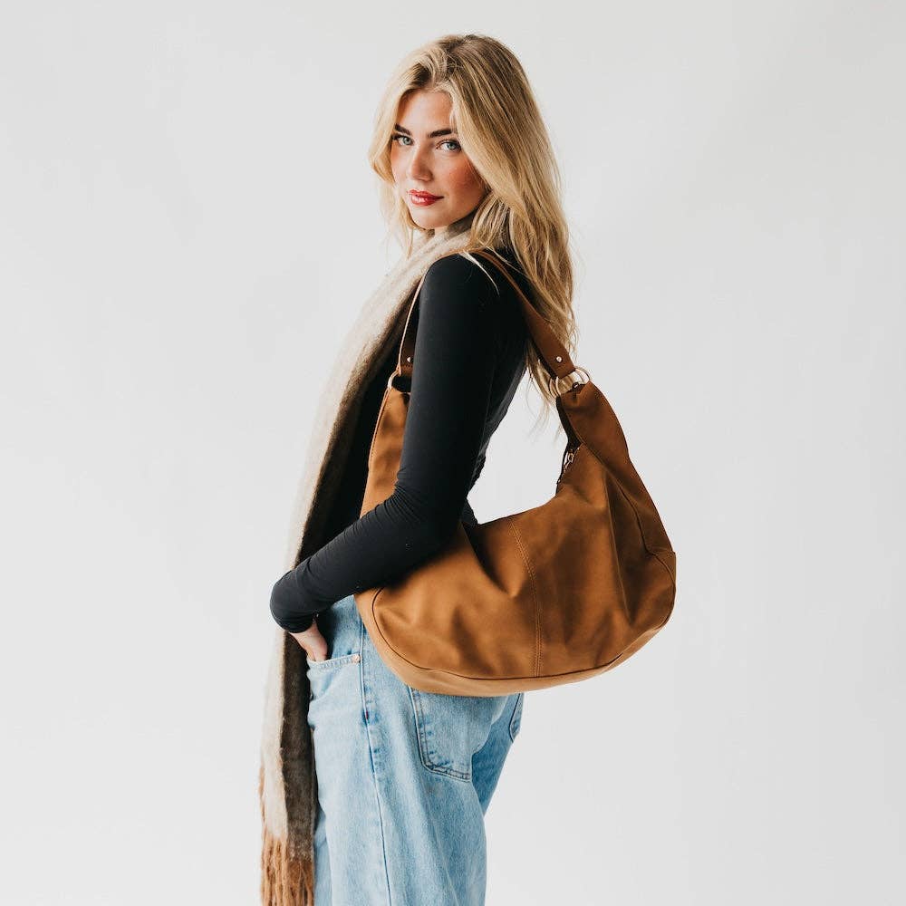 Tan suede hobo shoulder bag with a tassel