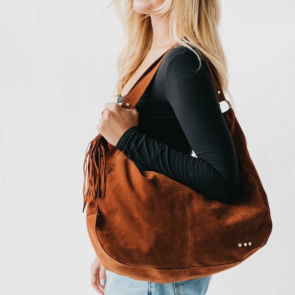 Tan suede hobo shoulder bag with a tassel