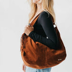 Tan suede hobo shoulder bag with a tassel