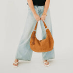 Tan suede hobo shoulder bag with a tassel