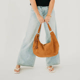 Tan suede hobo shoulder bag with a tassel