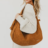 Tan suede hobo shoulder bag with a tassel