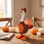 Table-sized goose figurine dressed in a holiday outfit