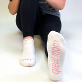 Person wearing white socks with 'great mom' text on a light background