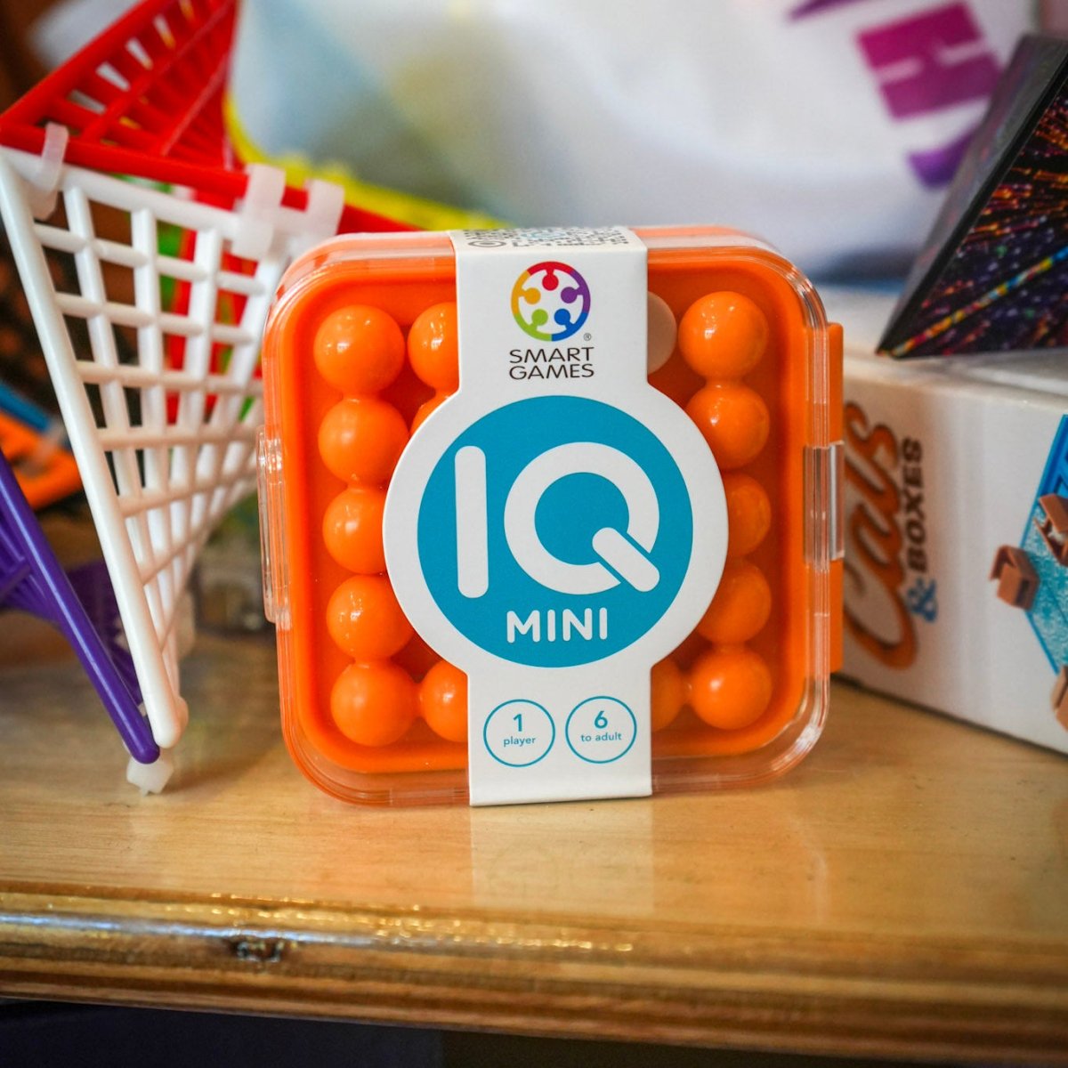 Container of IQ Mini toys on a table with colorful background