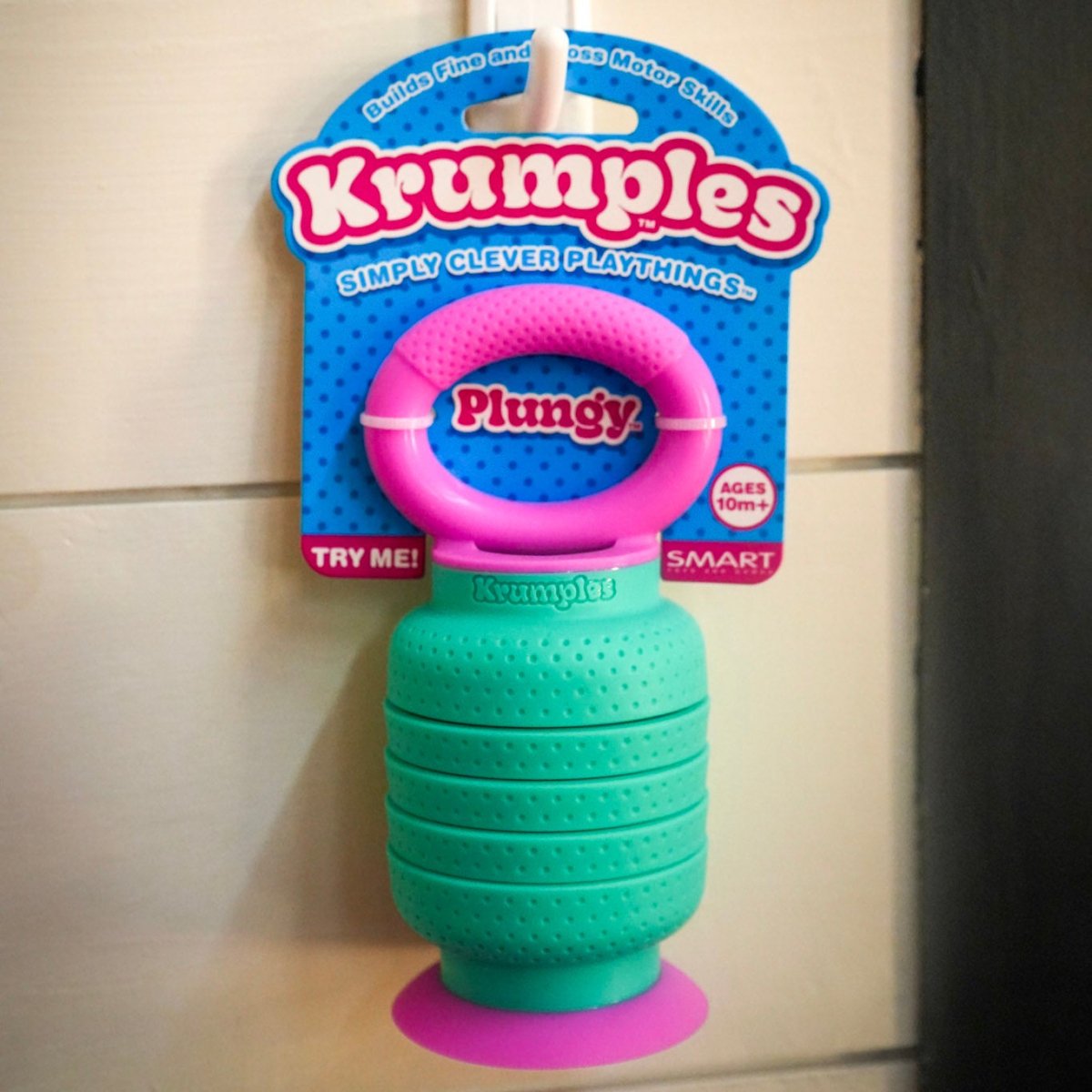 Mint green and pink Krumples Plungy toy on a tiled background. 