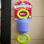 Krumples toy with a colorful label on a tiled wall background. 