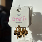 Gold apple charms on a display card with 'little words project' branding.