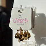 Gold apple charms on a display card with 'little words project' branding.