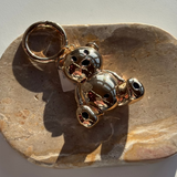 Little Words Project Gold-colored teddy bear backpack on a stone surface