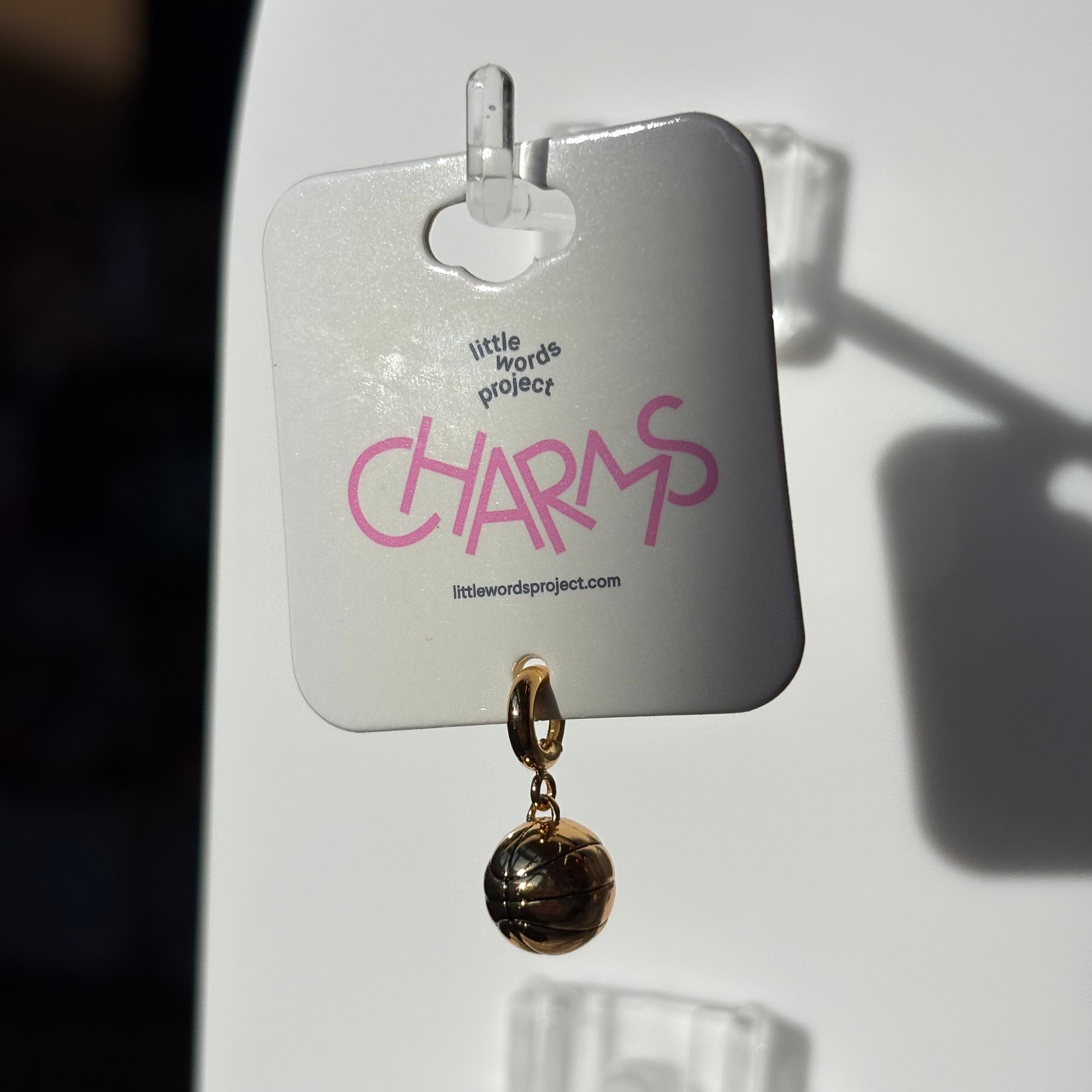 Gold basketball charm on a 'Little Words Project' card with 'CHARMS' text.