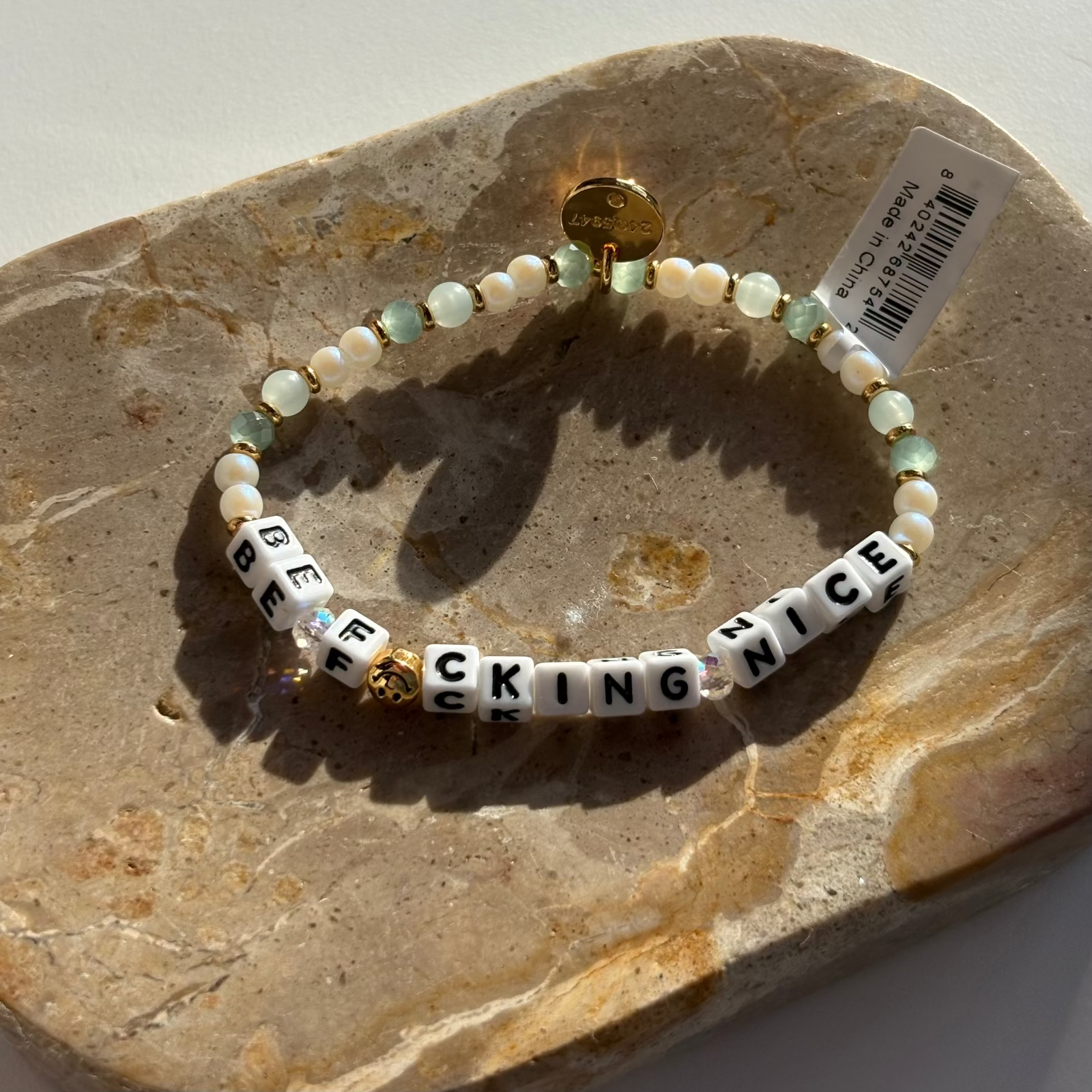 Little Words Project Bracelet with letter beads on a stone surface